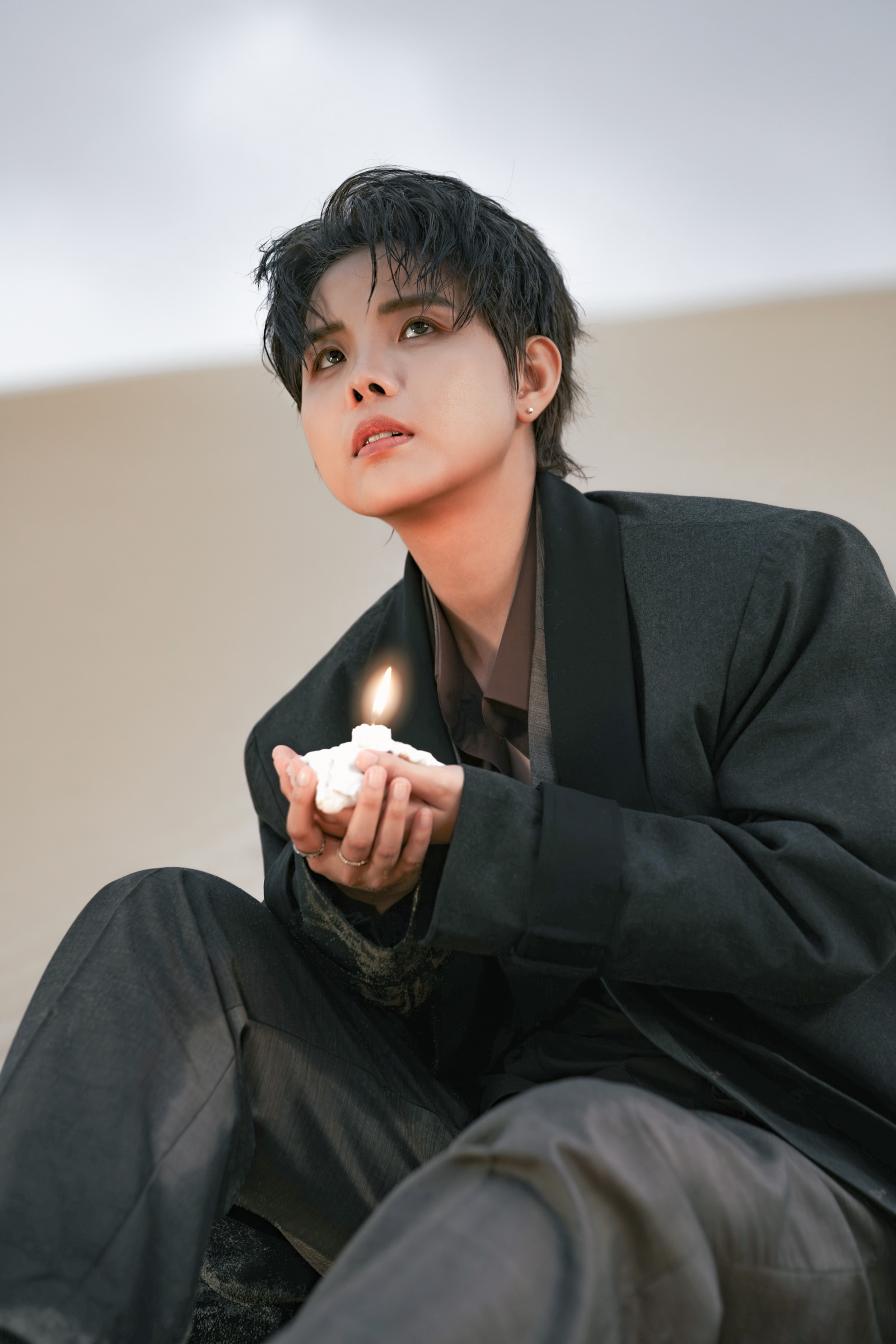 VUCATTUONG holding a lit candle in both hands